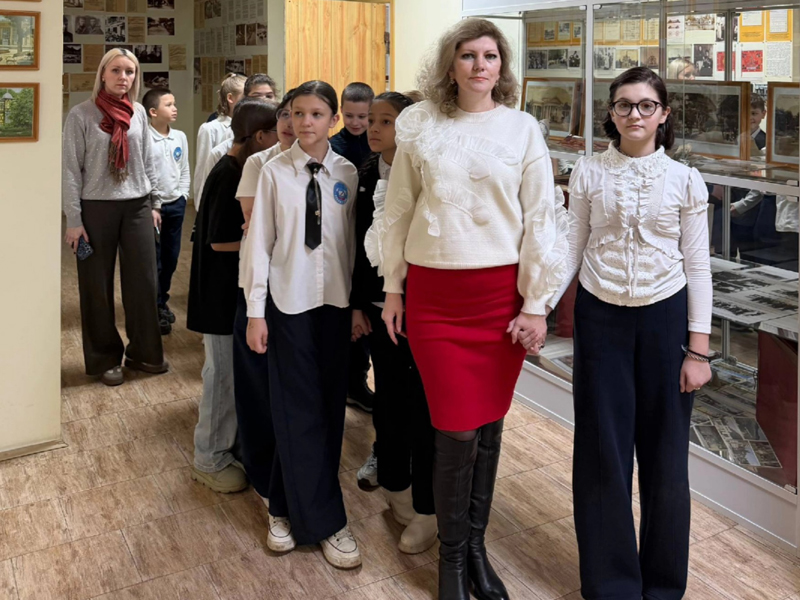 На фотографии начальник архива со школьниками.